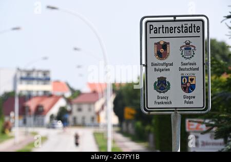 13 juillet 2021, Brandebourg, Eisenhüttenstadt: Un panneau avec l'inscription 'Twin Towns' se trouve à l'entrée de la ville. Sont listés les villes de Dimitroffgrad, Bulgarie, Sarre, Allemagne, Drancy, France et Glogow, Pologne. Photo: Soeren Stache/dpa-Zentralbild/dpa Banque D'Images