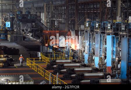 13 juillet 2021, Brandebourg, Eisenhüttenstadt: Laminoir à chaud d'ArcelorMittal. Les serpentins à bande chaude d'un poids maximal de 34 t sont produits à partir de dalles d'une épaisseur de 225 millimètres et d'une longueur maximale de 12 mètres. Photo: Soeren Stache/dpa-Zentralbild/dpa Banque D'Images