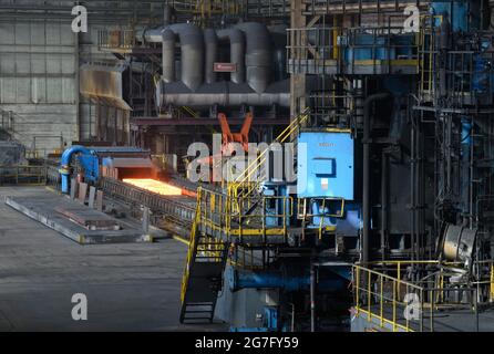 13 juillet 2021, Brandebourg, Eisenhüttenstadt: Laminoir à chaud d'ArcelorMittal. Les serpentins à bande chaude d'un poids maximal de 34 t sont produits à partir de dalles d'une épaisseur de 225 millimètres et d'une longueur maximale de 12 mètres. Photo: Soeren Stache/dpa-Zentralbild/dpa Banque D'Images