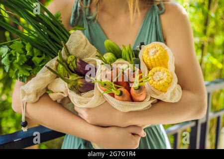 Ensemble de légumes frais dans un sac réutilisable entre les mains d'une jeune femme. Concept zéro déchet Banque D'Images