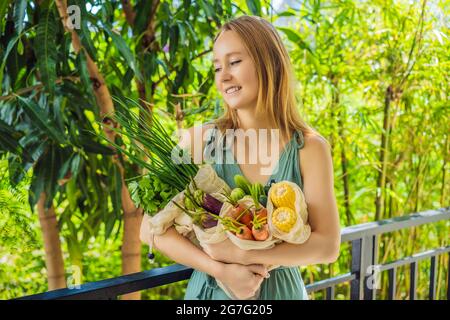 Ensemble de légumes frais dans un sac réutilisable entre les mains d'une jeune femme. Concept zéro déchet Banque D'Images