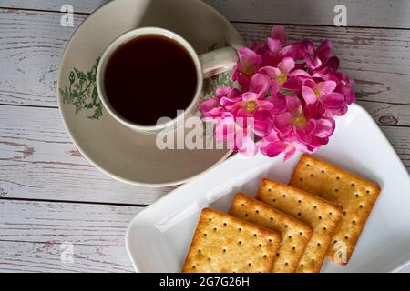 Petit-déjeuner composé de crackers à la crème et d'une tasse de thé. Points de mise au point sélective. Arrière-plan flou Banque D'Images