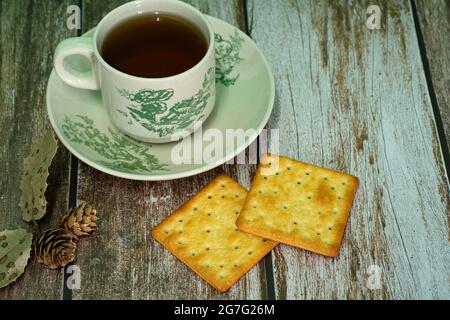 Petit-déjeuner composé de crackers à la crème et d'une tasse de thé. Points de mise au point sélective. Arrière-plan flou Banque D'Images