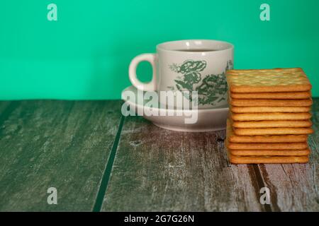 Petit-déjeuner composé de crackers à la crème et d'une tasse de thé. Points de mise au point sélective. Arrière-plan flou Banque D'Images