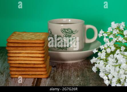 Petit-déjeuner composé de crackers à la crème et d'une tasse de thé. Points de mise au point sélective. Arrière-plan flou Banque D'Images