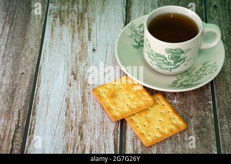 Petit-déjeuner composé de crackers à la crème et d'une tasse de thé. Points de mise au point sélective. Arrière-plan flou Banque D'Images