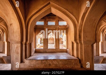 Salle de bains queen size de Vijayanagara Empire. 3 côtés de la piscine sèche carrée avec ses murs, ses couloirs et ses halls en pierre brune. Hampi, Karnataka, Ind Banque D'Images