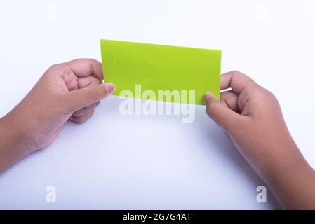 Pliage manuel d'un papier de couleur isolé sur fond blanc Banque D'Images