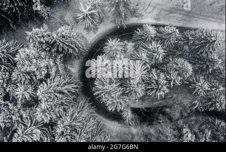 Kekesteto, Hongrie - vue aérienne d'une route sinueuse dans les montagnes Matra près de Kekesteto en neige lourde avec des pins enneigés par une froide journée d'hiver. Haut faire Banque D'Images
