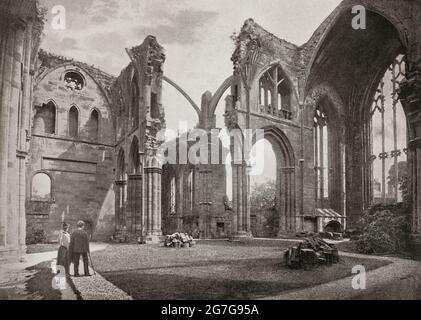 Vue de la fin du XIXe siècle des touristes de l'abbaye de St Mary, Melrose, un monastère en partie en ruines de l'ordre cistercien de Melrose, dans le Roxburghshire, aux frontières écossaises. Il a été fondé en 1136 par des moines cisterciens à la demande du roi David Ier d'Écosse et fut la maison principale de cet ordre dans le pays jusqu'à la réforme écossaise. L'abbaye a résisté à un assaut final, et certains de ses murs montrent encore les marques de feu de canon après avoir été bombardé par les troupes d'Oliver Cromwell pendant la guerre civile anglaise. Banque D'Images