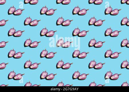 Deux moitiés répétées d'oignon non pelé mûr brut sur fond bleu blanc. Oignon italien Ramata di Milano. Section transversale légumes racines dans la peau. Foo Banque D'Images