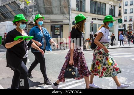 Groupe de femmes portant des chapeaux verts lors d'une visite guidée à pied de la ville - Paris, France. Banque D'Images