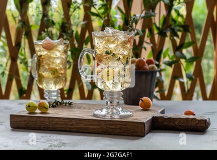 Deux verres avec thé glacé maison aux groseilles à maquereau ou limonade aux thymes. Banque D'Images