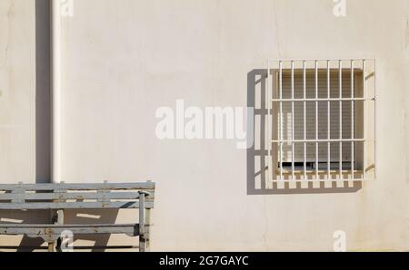 Banc en bois de couleur bleue devant un mur blanc avec fenêtre par temps ensoleillé Banque D'Images