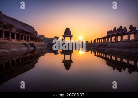 Vue sur le lever du soleil à Pushkarni, réservoir de Sri Krishna en ruines. côté sud de la piscine avec sanctuaire. Rochers et montagne à l'horizon. Hampi, karnataka, Inde. Banque D'Images