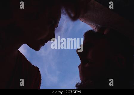 Silhouettes homme et femme sur fond bleu ciel de coucher de soleil. Concept de la Saint-Valentin. Banque D'Images
