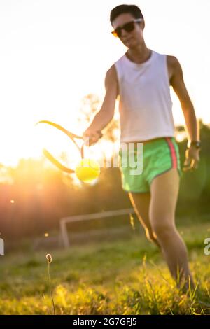 Jeune belle femme avec des cheveux courts jouer au tennis en plein air Banque D'Images