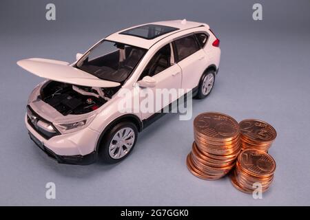 Modèle de voiture miniature et relevé financier avec pièces. Financement et prêt de voiture, économiser de l'argent pour une voiture ou des concepts de conception de matériaux. Caserta, Italie, juillet Banque D'Images