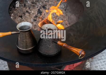 Préparation du café turc avec du cezve noir ou de l'ibrik lors du festival de la cuisine de rue Banque D'Images