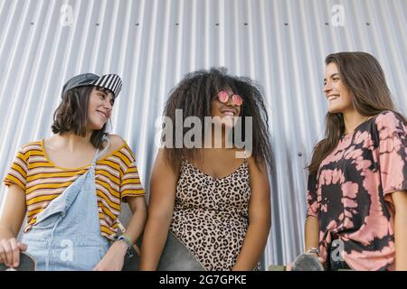 Trois belles jeunes femmes de différentes races avec leurs longues planches et souriantes Banque D'Images