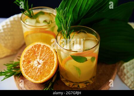 Limonade à l'orange, au romarin et à la menthe en verre sur la table. Boisson fraîche d'été Banque D'Images