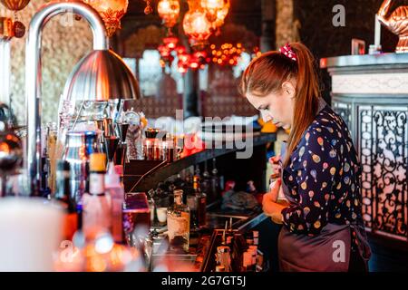 Barman spécialisé garni de cocktails frais dans des verres placés sur le comptoir du bar Banque D'Images