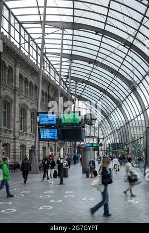 Les voyageurs passent par l'atrium moderne de la gare SNCF de Strasbourg, France. Banque D'Images