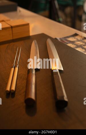 Couteaux tranchants placés sur une table en bois dans un restaurant asiatique Banque D'Images