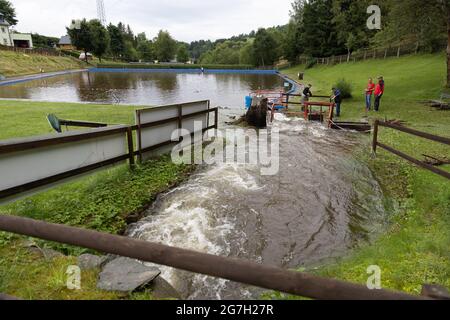 13 juillet 2021, Saxe, Jöhstadt: Des travaux de nettoyage sont en cours après une inondation éclair dans le district de Jöhstadt, à Steinbach, dans l'Erzgebirgskreis. Le lendemain de l'inondation éclair, les résidents, les chantiers de construction, les pompiers et les agents de secours sont occupés à nettoyer. Les débris entrants bloquent toujours les évacuations. L'un des habitants de Jöhstädt a été balayé par l'inondation éclair, il est toujours absent. Photo: Ronny Küttner/dpa Banque D'Images