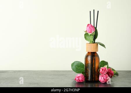 Bouteille à diffuseur humide avec bâtonnets et roses roses Banque D'Images