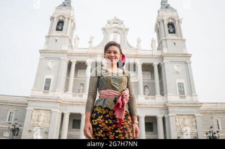 Jeune femme indonésienne heureuse de Bali ayant des vacances en Europe - attrayante et gaie balinaise touriste fille dans la tenue traditionnelle tournée dans le Banque D'Images