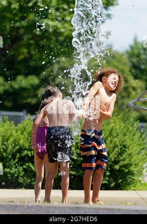 Trois enfants jouent dans des jeux aquatiques et des fontaines à Québec, au Canada Banque D'Images