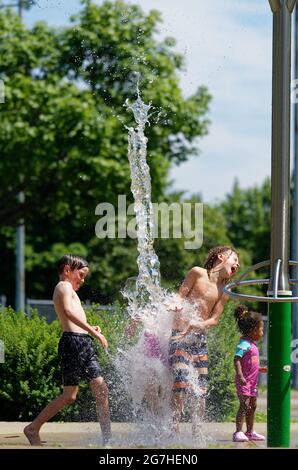 Trois enfants jouent dans des jeux aquatiques et des fontaines à Québec, au Canada Banque D'Images