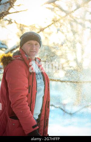 Portrait d'un homme en une journée enneigée dans la forêt. Le gars en vêtements de sport d'hiver. Banque D'Images