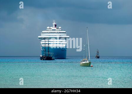 Des navires de différentes tailles sous le ciel lourd dérivant près de l'île Grand Cayman (îles Caïman). Banque D'Images
