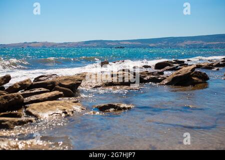 Bord de mer des Rocheuses. Paysage d'été. L'eau gécoute et bat contre les pierres. Banque D'Images