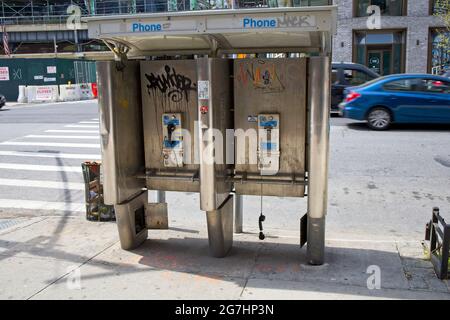 New York, NY, Etats-Unis - 14 juillet 2021: Les anciennes boîtes de téléphone à pièces dans un état de décomposition Banque D'Images