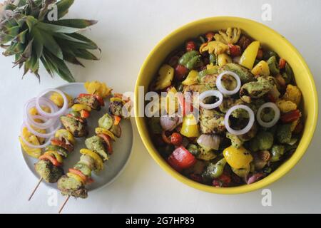 Kebab au poulet et à l'ananas. Un plat de morceaux de poulet et de poivrons marinés avec du masala à la coriandre et des tranches d'ananas grillées sur une brochette Banque D'Images