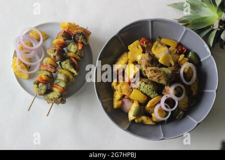 Kebab au poulet et à l'ananas. Un plat de morceaux de poulet et de poivrons marinés avec du masala à la coriandre et des tranches d'ananas grillées sur une brochette Banque D'Images