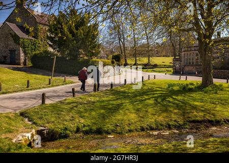 Royaume-Uni, Angleterre, Derbyshire, Tissington, visiteurs en cours d'eau traversant le green par Old School House Banque D'Images