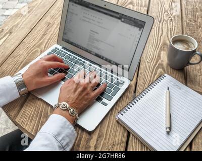 Les mains d'une femme d'affaires travaillent avec un ordinateur portable. Concept de bureau à domicile. Vue de dessus. Banque D'Images