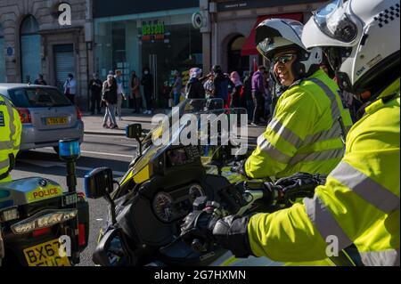 LONDRES - 29 MAI 2021 : un motard de la police britannique souriant lors d'un rassemblement de protestation de la liberté pour la Palestine dans une rue de Londres Banque D'Images