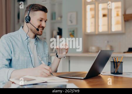 Concept d'apprentissage à distance. Millenning Guy étudiant dans les montres webinar a des leçons en ligne pendant la quarantaine aime l'éducation sur Internet boissons Banque D'Images