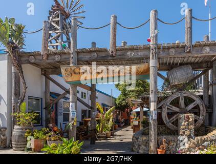 Cayucos, CA, Etats-Unis - 10 juin 2021 : construction pittoresque en bois gris élaboré à l'entrée du restaurant et pub Schooners sous un ciel bleu. Gree Banque D'Images