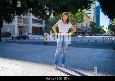 Femme dans le centre-ville Plaza entouré par de grands bâtiments Banque D'Images