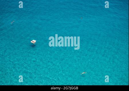 Tropea, Italie. 12 juillet 2021. Les gens vus appréciant les eaux cristallines à Tropea. Situé sur la "Côte des Dieux" dans la région italienne du sud de la Calabre, Tropea a reçu le titre de "hameau des hameaux" (borgo dei borghi) pour ses beautés historiques et naturelles, avec les eaux du drapeau bleu en 2021. Malgré les restrictions de Covid-19, le tourisme semble être de retour dans le hameau. Crédit : SOPA Images Limited/Alamy Live News Banque D'Images