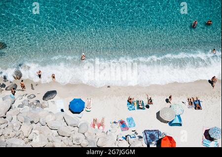 Tropea, Italie. 12 juillet 2021. Les gens se baignent au soleil sur une plage publique à Tropea. Situé sur la "Côte des Dieux" dans la région italienne du sud de la Calabre, Tropea a reçu le titre de "hameau des hameaux" (borgo dei borghi) pour ses beautés historiques et naturelles, avec les eaux du drapeau bleu en 2021. Malgré les restrictions de Covid-19, le tourisme semble être de retour dans le hameau. Crédit : SOPA Images Limited/Alamy Live News Banque D'Images