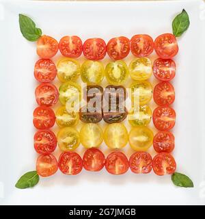 Différentes variétés de tomates cerises servies dans une salade isolée sur fond blanc. Banque D'Images