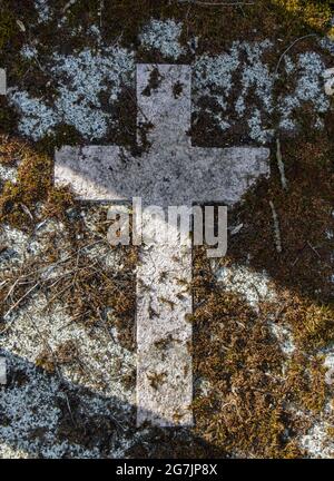 Une croix de pierre sur une pierre tombale dans un cimetière. Banque D'Images