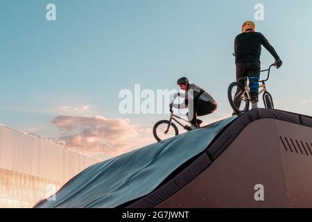 Kazan, Russie - 12 septembre 2020 : jeunes coureurs sur des vélos bmx sur la rampe du parc de skate dans le parc public de la ville pour les loisirs actifs. Banque D'Images
